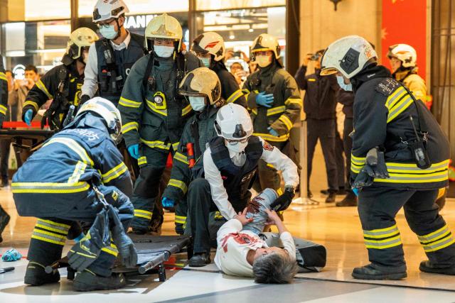 First responders attend to a man playing the role of a wounded victim during a security drill at the MRT City Hall Station in Taipei on December 26, 2025. Authorities in Taipei held a drill on December 26 simulating bomb and knife attacks in transportation hubs to bolster responses following a deadly stabbing rampage in the Taiwanese capital. (Photo by HUANG YU CHIEN / AFP)