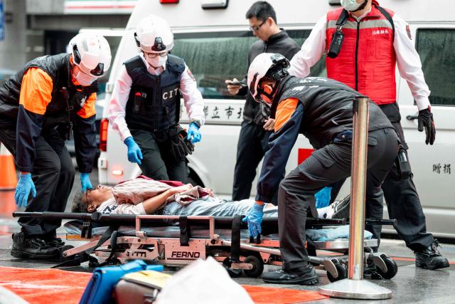 First responders attend to a man playing the role of a wounded victim during a security drill at the MRT City Hall Station in Taipei on December 26, 2025. Authorities in Taipei held a drill on December 26 simulating bomb and knife attacks in transportation hubs to bolster responses following a deadly stabbing rampage in the Taiwanese capital. (Photo by HUANG YU CHIEN / AFP)