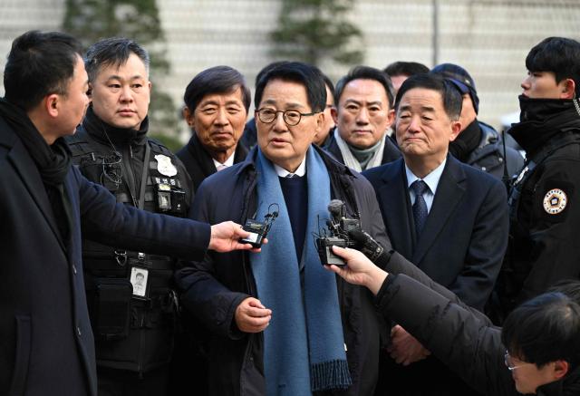 Park Jie-won (C), former spy agency chief under ex-president Moon Jae-in, speaks to reporters as he arrives to attend a trial related to the killing of a fisheries official near the inter-Korean sea border in 2020, at the Seoul Central District Court in Seoul on December 26, 2025. A South Korean court acquitted on December 26, a former top security adviser and other senior officials over the alleged cover-up of the 2020 killing of a fisheries official by Pyongyang. (Photo by Jung Yeon-je / AFP)