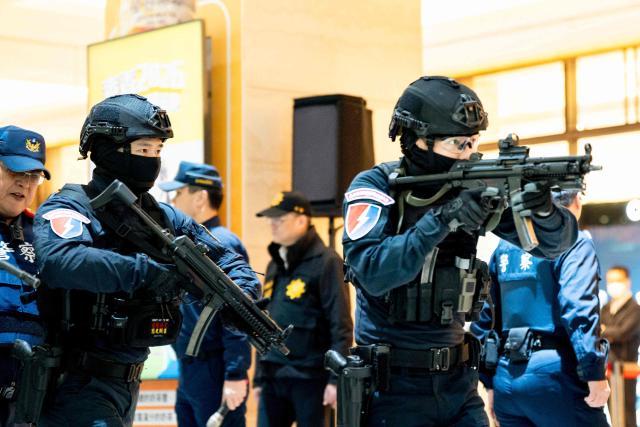 Taiwanese police officers aim their weapons as they take part in a security drill in Taipei on December 26, 2025. Authorities in Taipei held a drill on December 26 simulating bomb and knife attacks in transportation hubs to bolster responses following a deadly stabbing rampage in the Taiwanese capital. (Photo by HUANG YU CHIEN / AFP)