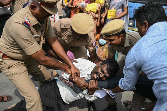 Police personnel detain a teacher during a protest demanding salary hikes and regularization of government jobs in Chennai on December 26, 2025. (Photo by R.Satish BABU / AFP)