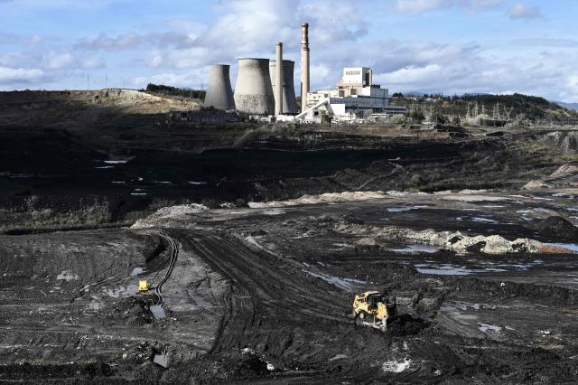 This photograph shows a vehicle during operating during an excavation at a interrupted lignite-fired power plant, near Ptolemaida, in northwestern Greece on November 20, 2025. As part of an environmental drive that became known as the European Union Green Deal, Greece in 2019 decided to drastically cut back on the use of lignite in electricity production. Despite decades of air and water pollution that have verifiably caused cancer and other ailments, the residents of Agios Dimitrios village will be sorry to see the Public Power Corporation plant -- a source of employment for many -- decommissioned. The Agios Dimitrios plant, just a few hundred metres from the village, is scheduled to shut in May 2026. (Photo by Sakis Mitrolidis / AFP)