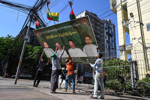 Members of Union Solidarity and Development Party (USDP) remove their signboard on the final day of the campaign ahead of the start of Myanmar's general election in Yangon on December 26, 2025. Myanmar's junta will preside over elections starting on December 28, advertising the vote as a return to democratic normality five years after staging a coup that triggered civil war. (Photo by Sai Aung MAIN / AFP)
