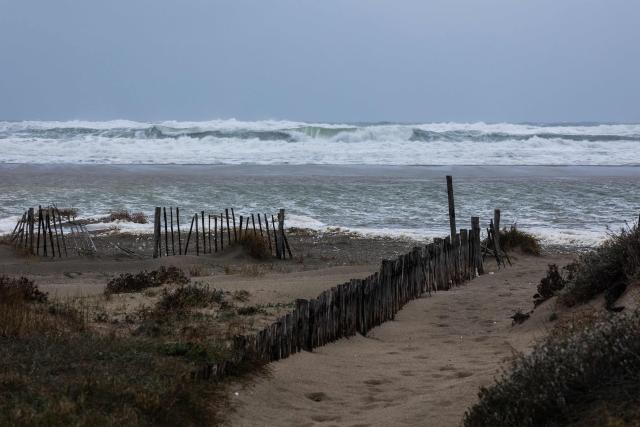This photograph shows waves of the Mediterranean Sea overflowing on the dunes of a beach at Canet en Roussillon in the Pyrenees-Orientales department in the south-west of France on December 26, 2025. Currently under a Meteo France alert, the Pyrenees Orientales are experiencing flooding and rainfall of more than 200mm per hour across the department. (Photo by Jean-Christophe MILHET / AFP)