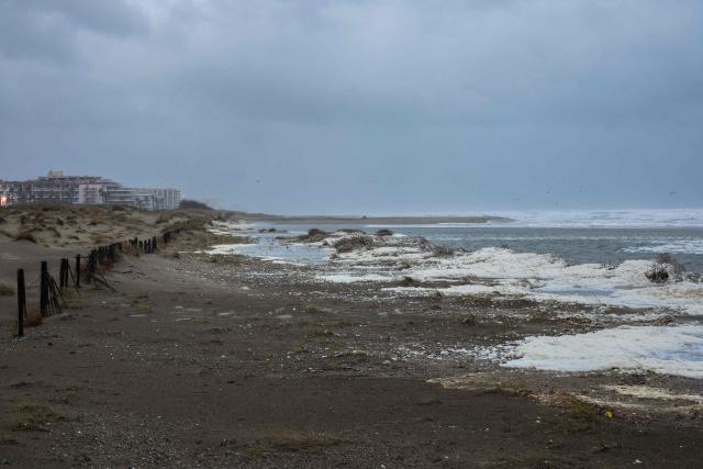 This photograph shows waves of the Mediterranean Sea overflowing on the dunes of a beach at Canet en Roussillon in the Pyrenees-Orientales department in the south-west of France on December 26, 2025. Currently under a Meteo France alert, the Pyrenees Orientales are experiencing flooding and rainfall of more than 200mm per hour across the department. (Photo by Jean-Christophe MILHET / AFP)