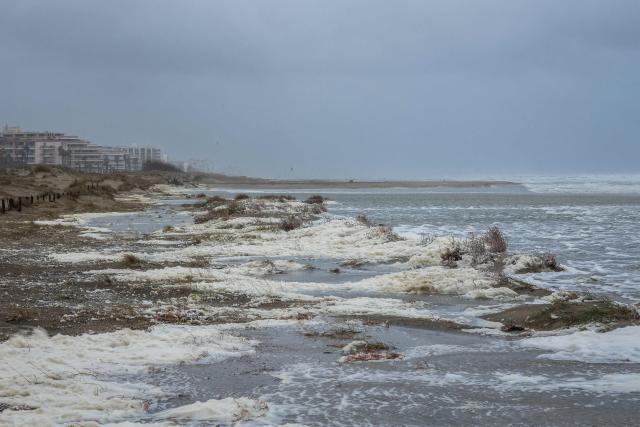 This photograph shows waves of the Mediterranean Sea overflowing on the dunes of a beach at Canet en Roussillon in the Pyrenees-Orientales department in the south-west of France on December 26, 2025. Currently under a Meteo France alert, the Pyrenees Orientales are experiencing flooding and rainfall of more than 200mm per hour across the department. (Photo by Jean-Christophe MILHET / AFP)