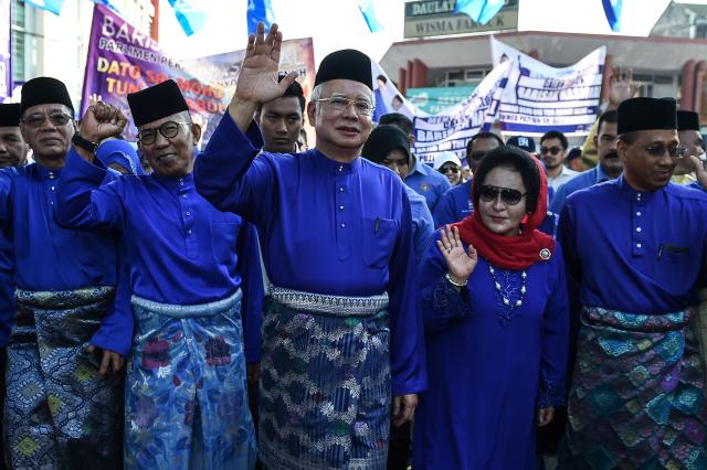 (FILES) Malaysia's Prime Minister Najib Razak (C) and his wife Rosmah Mansor arrive at the nomination centre to hand over election documents in Pekan on April 28, 2018. Former Malaysian prime minister Najib Razak was found guilty on December 26, 2025 of abusing his power to plunder millions of dollars from the country's now defunct sovereign wealth fund and laundering the proceeds. (Photo by Mohd RASFAN / AFP)