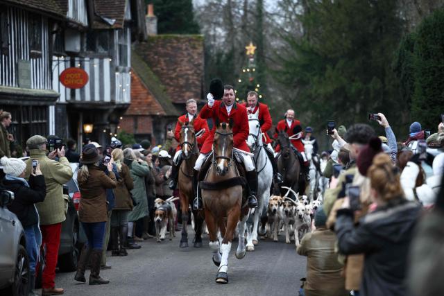 Members of the public line the road to view members of the Old Surrey, Burstow and West Kent Hunt and their hounds, making their way through the village of Chiddingstone during the annual Boxing Day hunt, south of London on December 26, 2025. (Photo by HENRY NICHOLLS / AFP)