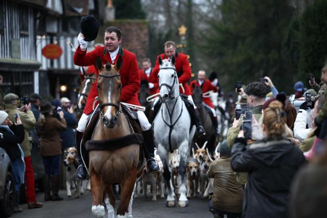 Members of the public line the road to view members of the Old Surrey, Burstow and West Kent Hunt and their hounds, making their way through the village of Chiddingstone during the annual Boxing Day hunt, south of London on December 26, 2025. (Photo by HENRY NICHOLLS / AFP)