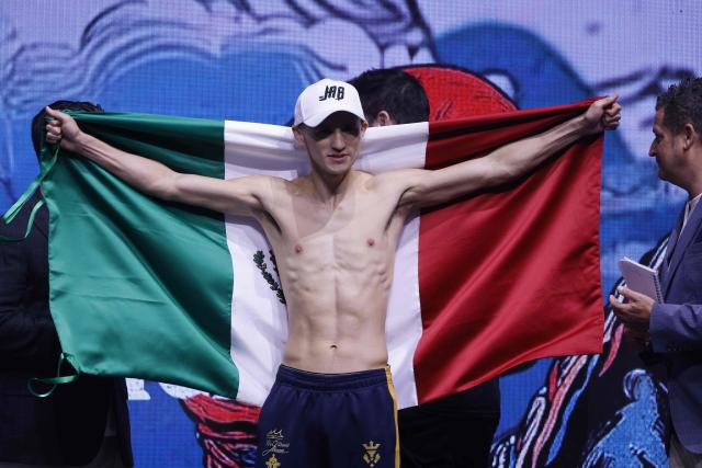 Mexico's boxer David Picasso holds the Mexican flag after their weigh-in with Japan's boxer Naoya Inoue (unseen) on December 26, 2025, in Boulevard Entertainment City in Riyadh, ahead of their final major fight card of the year presented by Riyadh season intitle “The Ring V night of Samurai”. The fight will take place at the Mohammed Abdo Arena, in Riyadh on December 27, 2025. (Photo by Fayez NURELDINE / AFP)