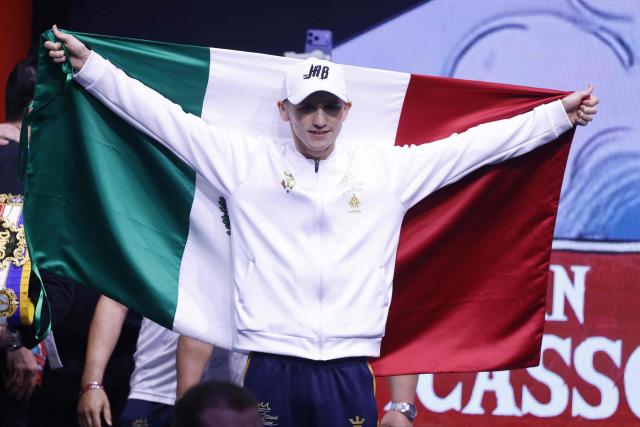 Mexico's boxer David Picasso holds the Mexican flag after their weigh-in with Japan's boxer Naoya Inoue (unseen) on December 26, 2025, in Boulevard Entertainment City in Riyadh, ahead of their final major fight card of the year presented by Riyadh season intitle “The Ring V night of Samurai”. The fight will take place at the Mohammed Abdo Arena, in Riyadh on December 27, 2025. (Photo by Fayez NURELDINE / AFP)