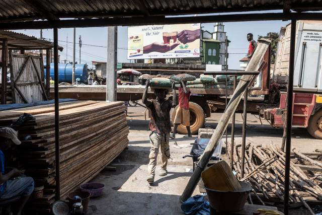 Workers carry bags full of cement to a nearby warehouse in the neighborhood of Cosa in Conakry, on December 26, 2025, ahead of Guinea’s Presidential election on December 28, 2025. (Photo by PATRICK MEINHARDT / AFP)