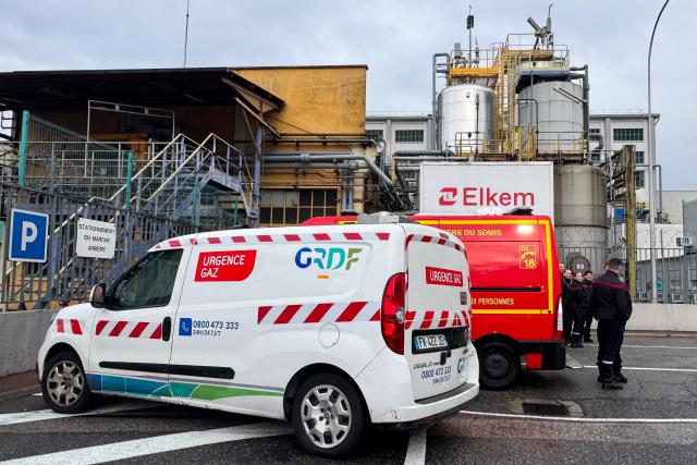 (FILES) Firefighters stand next to fire trucks and a GRDF (a French natural gas providor) truck at the site of Elkem Silicones chemical plant, in Saint-Fons, central-eastern France on December 22, 2025, following an explosion. A second employee died following December 22 explosion at the Elkem Silicones chemical plant in Saint-Fons, near Lyon, the prefecture told AFP on December 26, 2025. (Photo by Manon BILLING / AFP)