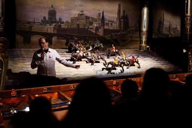 People play a Derby Game (mechanical horse race game) during the annual Festival du Merveilleux at the Musee des Arts Forains in Paris on December 26, 2025. (Photo by Dimitar DILKOFF / AFP)