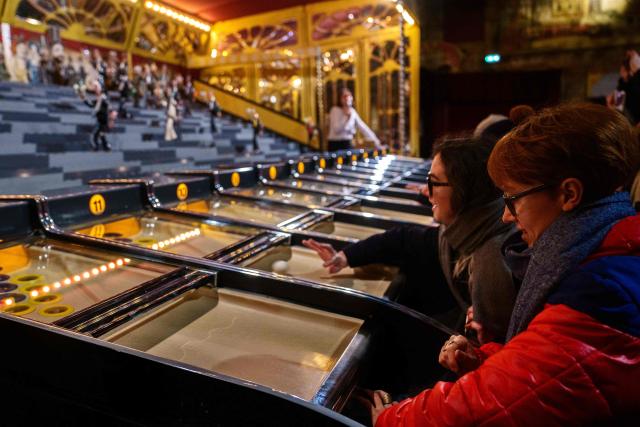 People play a Derby Game (mechanical horse race game) during the annual Festival du Merveilleux at the Musee des Arts Forains in Paris on December 26, 2025. (Photo by Dimitar DILKOFF / AFP)