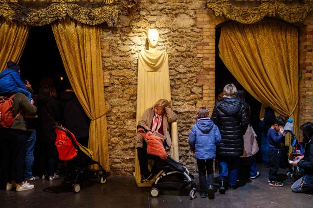 A woman takes rest during the annual Festival du Merveilleux at the Musee des Arts Forains in Paris on December 26, 2025. (Photo by Dimitar DILKOFF / AFP)