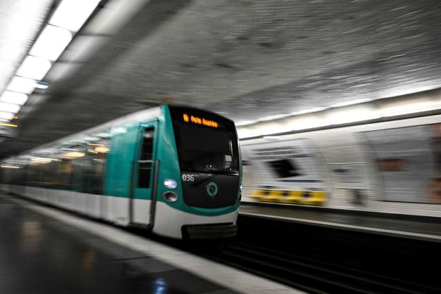 (FILES) This photograph shows a subway train entering a metro station in Paris on April 1, 2024. Three women were stabbed and wounded at three different Paris Metro stations, including Opera, Arts et Metiers and Republique, on December 26, 2025, by an attacker who is still at large said the RATP, the body that runs the network. (Photo by JULIEN DE ROSA / AFP)