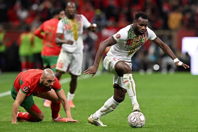 Morocco's midfielder #04 Sofyan Amrabat and Mali's midfielder #11 Lassana Coulibaly compete for the ball during the Africa Cup of Nations (CAN) Group A football match between Morocco and Mali at Prince Moulay Abdellah Stadium in Rabat on December 26, 2025. (Photo by Gabriel BOUYS / AFP)