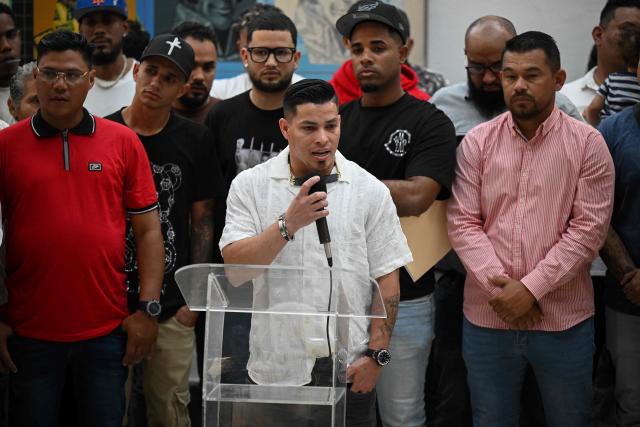 Nolberto Rafael Aguilar (C), one of the Venezuelans deported from El Salvador, speaks during a press conference at the Capital District Government headquarters in Caracas on December 26, 2025. Venezuelans among the 252 rounded up in the United States in March and sent to a notorious Salvadoran prison, demanded on December 26, 2025, to be given the chance to challenge their designation as gang members before US courts. (Photo by Federico PARRA / AFP)