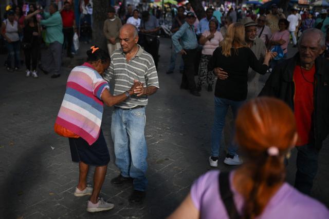 A couple of elderly people dance salsa at El Venezolano Square in downtown Caracas on December 26, 2025. (Photo by Federico PARRA / AFP)