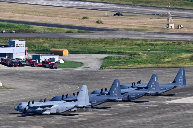 A US Marine Corps KC-130J Hercules and U.S. Air Force MC-130 J sit on the tarmac at José Aponte de la Torre Airport, formerly Roosevelt Roads Naval Station, on December 26, 2025 in Ceiba, Puerto Rico. The United States has deployed a major military force in the Caribbean and has recently intercepted oil tankers as part of a naval blockade against Venezuelan vessels it considers to be under sanctions. Since September, US forces have launched dozens of air strikes on boats that Washington alleges, without showing evidence, were transporting drugs. More than 100 people have been killed. (Photo by Miguel J. Rodriguez Carrillo / AFP)
