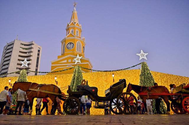 Horses-drawn carriage are seen at the historic center of Cartagena, Colombia, on December 26, 2025. Traditional horse-drawn carriages will be banned starting December 29, 2025, in Cartagena, a tourist jewel of Colombia, the local mayor announced on December 26. (Photo by Manuel PEDRAZA / AFP)