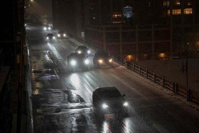 Cars are driven during a snowfall on December 26, 2025 in New York City. (Photo by ANGELA WEISS / AFP)