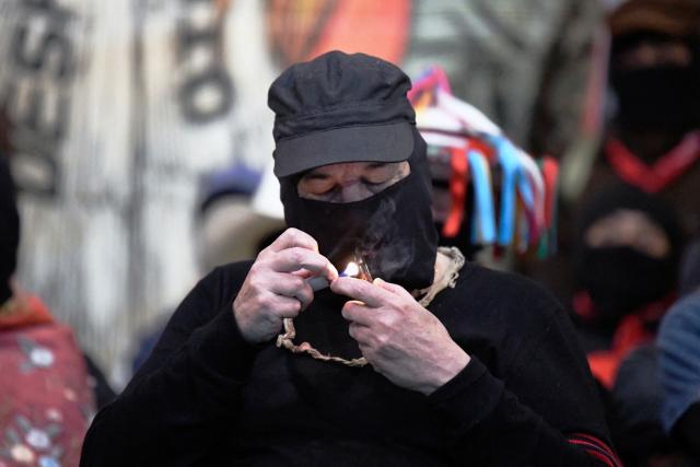 Former Subcommander, now Captain Marcos of the Zapatista Army of National Liberation (EZLN in Spanish), lights his pipe as he prepares to deliver a welcoming message to the meeting called “Of Pyramids, of Histories, of Loves and Heartbreaks” in the framework of the 32nd anniversary of his armed uprising in 1994, in the city of San Cristobal de las Casas, state of Chiapas, Mexico, on December 26, 2025. (Photo by Isaac GUZMAN / AFP)