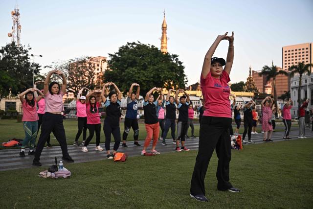 TOPSHOT - People take part in aerobics in Maha Bandula Park in Yangon on December 27, 2025, a day before the start of Myanmar's general election. (Photo by Lillian SUWANRUMPHA / AFP)