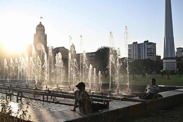 TOPSHOT - Women sit near fountains in Maha Bandula Park in Yangon on December 27, 2025, a day before the start of Myanmar's general election. (Photo by Lillian SUWANRUMPHA / AFP)