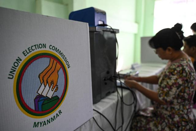 Members of Myanmar's Union Election Commission (UEC) prepare a voting station a day before the start of Myanmar's general election in Yangon on December 27, 2025. (Photo by NHAC NGUYEN / AFP)