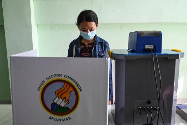 A member of Myanmar's Union Election Commission (UEC) prepares a voting station a day before the start of Myanmar's general election in Yangon on December 27, 2025. (Photo by NHAC NGUYEN / AFP)
