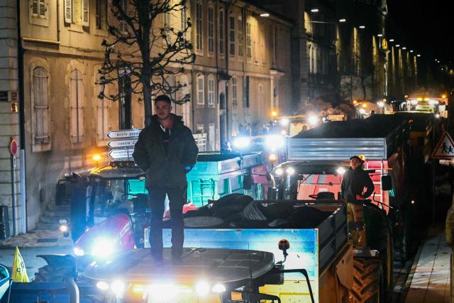 A farmer of "Coordination Rurale" (CR32) union stands on a tractor as they drive towards the Gers prefecture to protest against the French government's mandatory culling protocol for cattle herds affected by lumpy skin disease (dermatose nodulaire contagieuse), in Auch, southwestern France, on December 27, 2025. (Photo by Matthieu RONDEL / AFP)