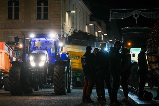 Farmers of "Coordination Rurale" (CR32) union stand next to tractors as they drive towards the Gers prefecture to protest against the French government's mandatory culling protocol for cattle herds affected by lumpy skin disease (dermatose nodulaire contagieuse), in Auch, southwestern France, on December 27, 2025. (Photo by Matthieu RONDEL / AFP)