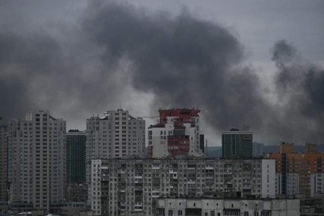This photograph taken on December 27, 2025 shows smoke rising above residential buildings following Russian drones and missiles attack, in Kyiv, amid the Russian invasion in Ukraine. Several powerful explosions rocked Kyiv on December 27, 2025 as authorities warned that the Ukrainian capital was under threat of missile attack. (Photo by AFP)