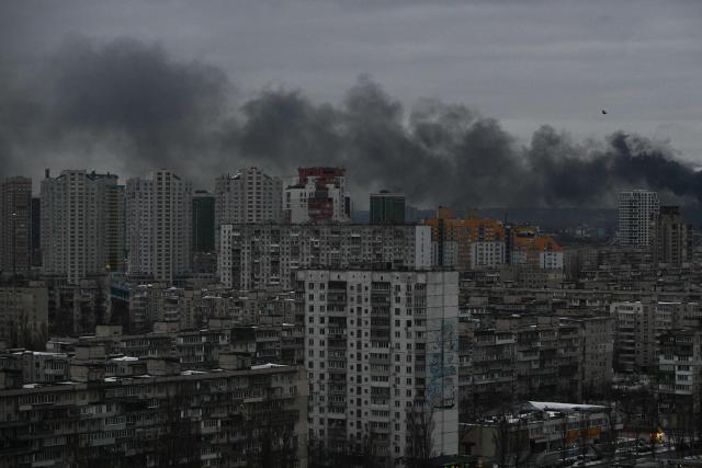 This photograph taken on December 27, 2025 shows smoke rising above residential buildings following Russian drones and missiles attack, in Kyiv, amid the Russian invasion in Ukraine. Several powerful explosions rocked Kyiv on December 27, 2025 as authorities warned that the Ukrainian capital was under threat of missile attack. (Photo by AFP)