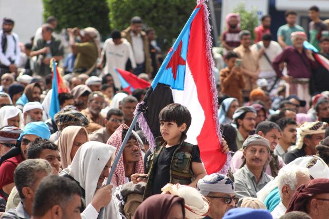 (FILES) A boy looks on as supporters of the Southern Transitional Council (STC), a coalition of separatist groups seeking to restore the state of South Yemen, hold South Yemen flags during a rally calling for the revival of the former independent state, in Aden on December 12, 2025. Saudi Arabia warned on December 27, 2025 it would back Yemen's government in any military confrontation with separatist forces and urged them to withdraw "peacefully" from recently-seized provinces. In recent weeks, separatists backed by the United Arab Emirates and seeking to revive the formerly independent state of South Yemen have made territorial gains. (Photo by Saleh Al-OBEIDI / AFP)