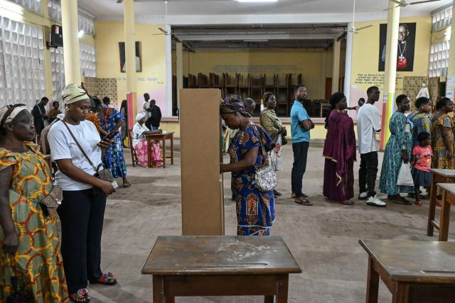 A voter marks her ballot paper in a voting booth at a polling station in Abidjan on December 27, 2025 during Ivory Coast's legislative elections. (Photo by Sia KAMBOU / AFP)
