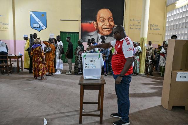 A voter casts his ballot at a polling station in Abidjan on December 27, 2025 during Ivory Coast's legislative elections. (Photo by Sia KAMBOU / AFP)