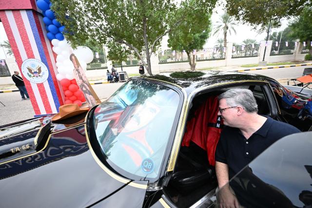 Charge d'Affaires at the US Embassy in Kuwait Steven Butler tours the Cars and Coffee Celebration of America exhibition held at the US Embassy in Kuwait City on December 27, 2025. The exhibition showcased a number of classic and modern American vehicles. (Photo by YASSER AL-ZAYYAT / AFP)
