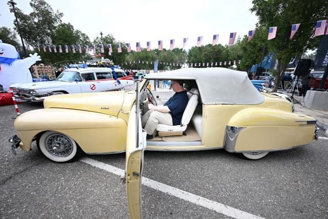 Charge d'Affaires at the US Embassy in Kuwait Steven Butler (C) tours the Cars and Coffee Celebration of America exhibition held at the US Embassy in Kuwait City on December 27, 2025. The exhibition showcased a number of classic and modern American vehicles. (Photo by YASSER AL-ZAYYAT / AFP)