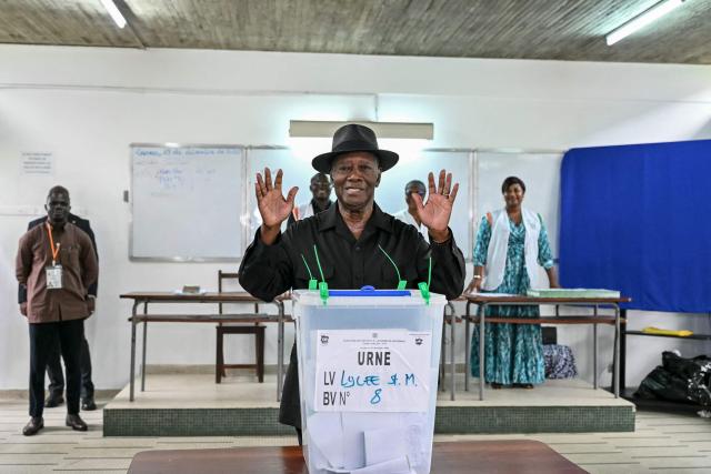 Ivory Coast's President Alassane Ouattara gestures after casting his ballot at a polling station at the Lycee Saint-Marie in Cocody, Abidjan, on December 27, 2025 during Ivory Coast's legislative elections. (Photo by SIA KAMBOU / AFP)