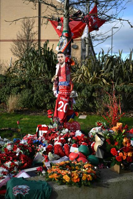 Flowers, scarves and shirts together with a large photograph can be seen at a memorial set up close to Anfield football ground for Liverpool's Portuguese forward Diogo Jota ahead of the English Premier League football match between Liverpool and Wolverhampton Wanderers at Anfield in Liverpool, north west England on December 27, 2025. Father of three Jota, who married his long-term partner Rute Cardoso 11 days before the accident, died alongside his brother after a Lamborghini they were travelling in came off the road and burst into flames in northern Spain in July. (Photo by Oli SCARFF / AFP)