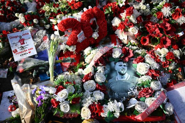 Flowers and photographs can be seen at a memorial set up close to Anfield football ground for Liverpool's Portuguese forward Diogo Jota ahead of the English Premier League football match between Liverpool and Wolverhampton Wanderers at Anfield in Liverpool, north west England on December 27, 2025. Father of three Jota, who married his long-term partner Rute Cardoso 11 days before the accident, died alongside his brother after a Lamborghini they were travelling in came off the road and burst into flames in northern Spain in July. (Photo by Oli SCARFF / AFP)