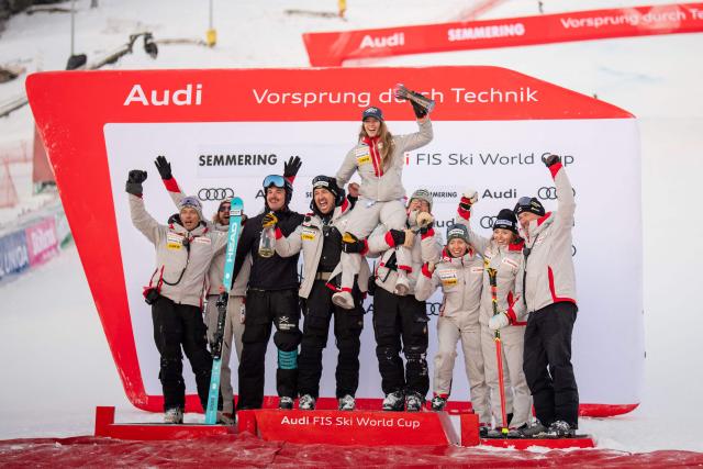 Second placed Switzerland's Camille Rast celebrates on the podium with her team after the women's giant slalom event of the FIS Alpine Ski World Cup in Semmering, Austria on December 27, 2025. (Photo by GEORG HOCHMUTH / APA / AFP) / Austria OUT