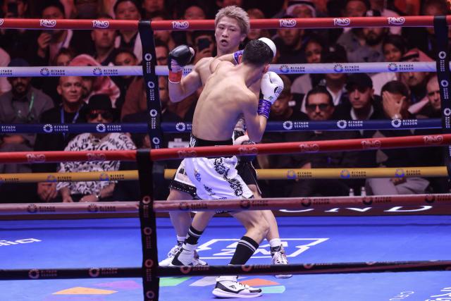 Japan's boxer Naoya Inoue (back) fights Mexico's boxer David Picasso in the "The Ring V night of Samurai" final major fight card of the year against at the Mohammed Abdo Arena in Riyadh on December 27, 2025. (Photo by Fayez NURELDINE / AFP)