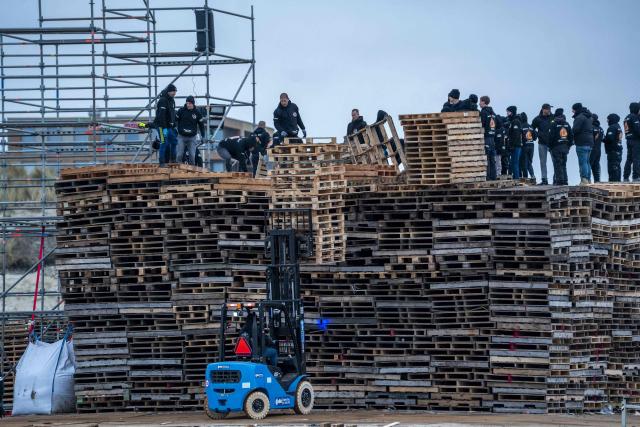 Workers install wooden pallets to build a giant bonfire at Duindorp beach in The Hague on December 27, 2025, ahead of this year's New Year's Eve celebration. (Photo by Lina Selg / ANP / AFP) / Netherlands OUT