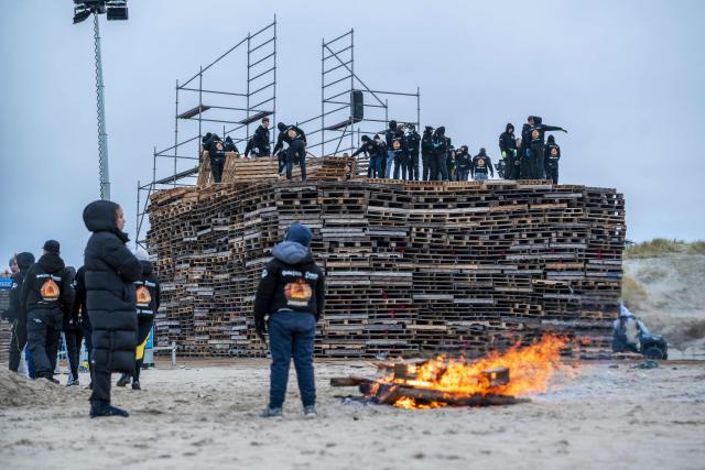 Workers install wooden pallets to build a giant bonfire at Duindorp beach in The Hague on December 27, 2025, ahead of this year's New Year's Eve celebration. (Photo by Lina Selg / ANP / AFP) / Netherlands OUT