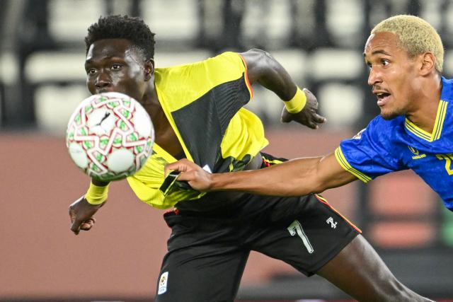 Uganda's forward #07 Rogers Mato and Tanzania's midfielder #25 Haji Mnoga vie during the Africa Cup of Nations (CAN) Group C football match between Uganda and Tanzania at Al Medina Stadium in Rabat on December 27, 2025. (Photo by SEBASTIEN BOZON / AFP)