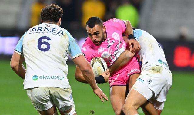 Stade Francais's French winger Joseph Marchant (C) is tackled during the French Top14 rugby union match between Aviron Bayonnais (Bayonne) and Stade Francais at Stade Jean Dauger in Bayonne, south-western France, on December 27, 2025. (Photo by Gaizka IROZ / AFP)
